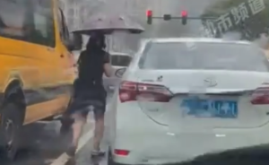 女子给冒雨等红灯小学生送伞