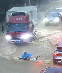 女子因大雨摔倒 众人上前帮助 热心司机雨中援手