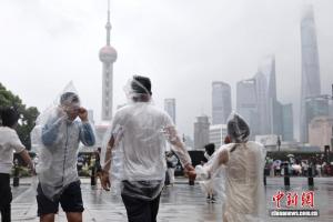 台风影响渐弱 上海外滩又热闹起来 游客冒雨感受风力
