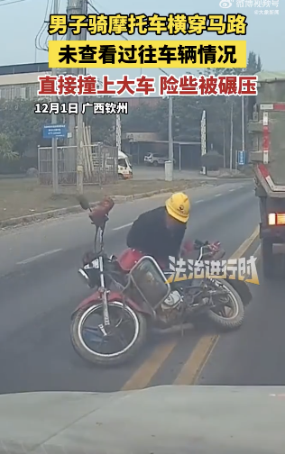 摩托车横穿马路撞上大车险遭碾压