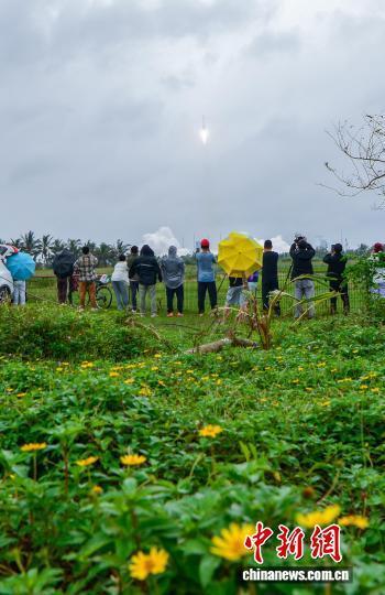 游客雨中观看火箭发射