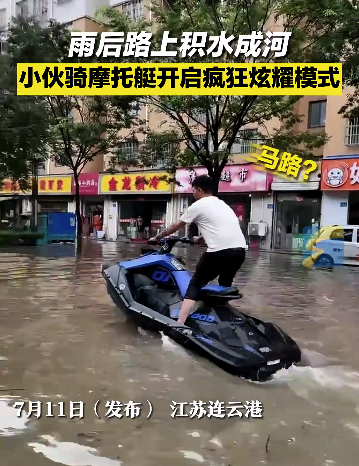 雨后路上积水成河 男子骑摩托艇水中炫耀