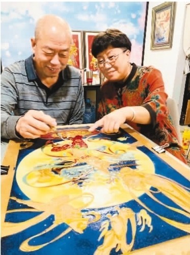 图为刘广全（左）、张英（右）夫妇正在“点蓝”。受访者供图