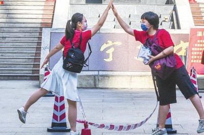 广西南宁市第二中学新民校区考点，老师（左）与考生击掌。　　新华社记者 曹祎铭摄