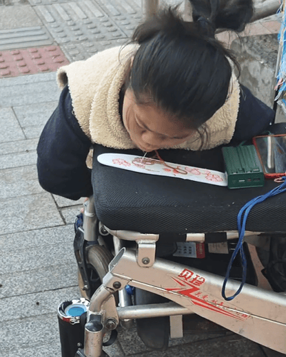 单亲妈妈手脚残疾 用嘴绣鞋垫养家