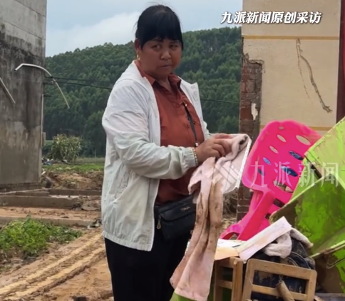 女子站泥堆中擦拭离世丈夫照片：和他的结婚照放在柜子里，才没冲走