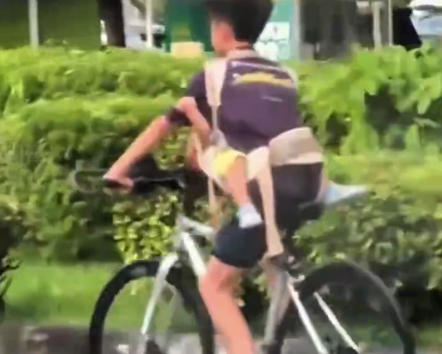 看得人手心冒汗！男孩胸前挂幼童在车流中骑行