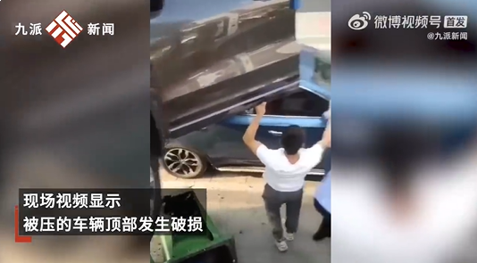 女子倒车不当悬空压在路边车顶