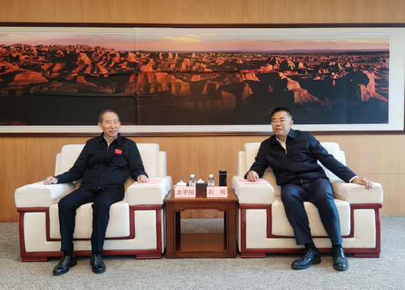 中国国际文化传播中心执行主席龙宇翔（右）与克拉玛依市委书记石岗亲切交流