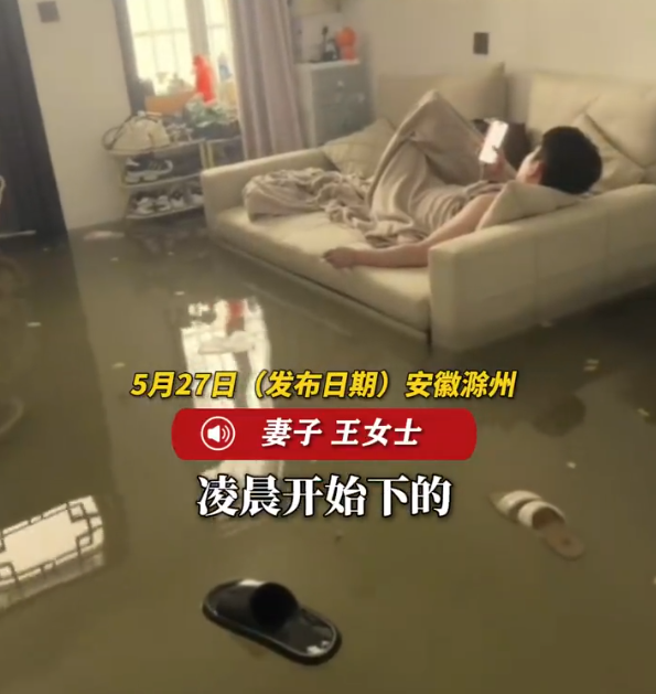 暴雨淹了家 夫妻俩1个玩手机1个补觉 淡定应对积水
