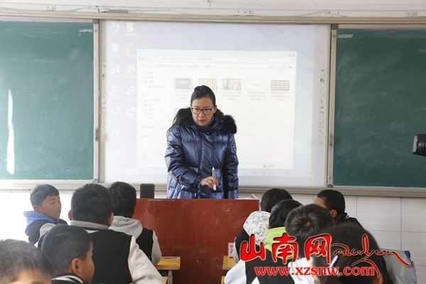 图为马丹在为东辉中学学生上音乐课