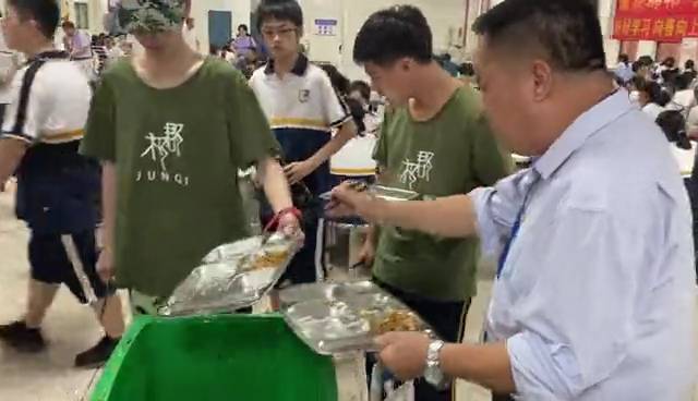 湖南一校长站垃圾桶旁吃学生剩饭 当事人：每天3顿