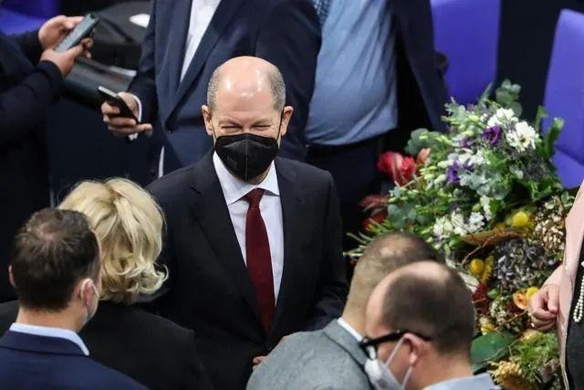 德国新任总理朔尔茨向默克尔献花