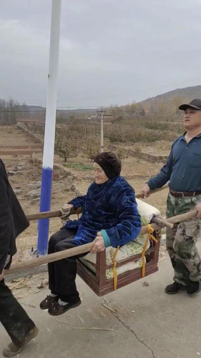 一家人抬轿挑担接百岁母亲到自家住(百岁母亲)