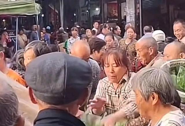 摊主卖菜苗遭老人哄抢,老板娘一直往回夺苗,三轮车都差点保不住