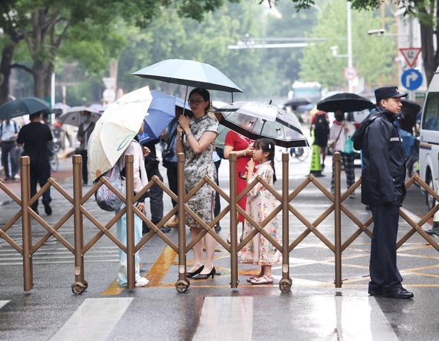 考点积水民警冒雨为考生铺路 风雨无阻保高考畅通