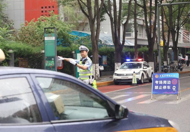 考点积水民警冒雨为考生铺路 风雨无阻保高考畅通