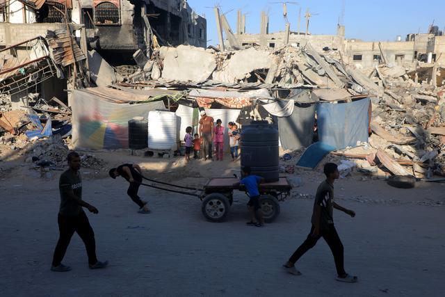 巴勒斯坦人在废墟中为孩子洗澡 生活坚韧不息