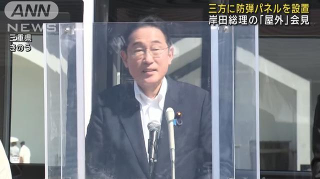 日本首相隔着防弹面板接受采访