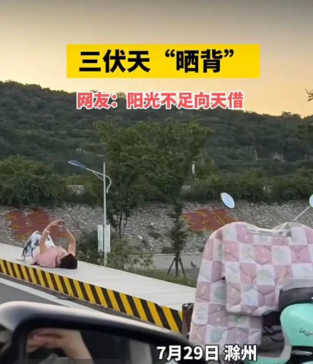 三伏天有人竟躺在小区道路上晒背 养生新潮流？