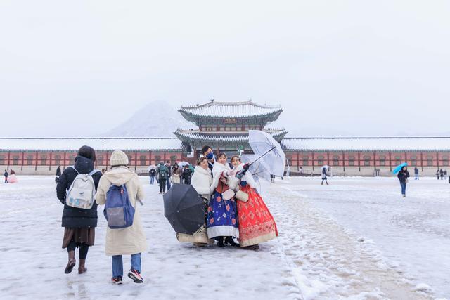 11月27日，在韩国首都首尔，人们游览雪中的景福宫。新华社 图