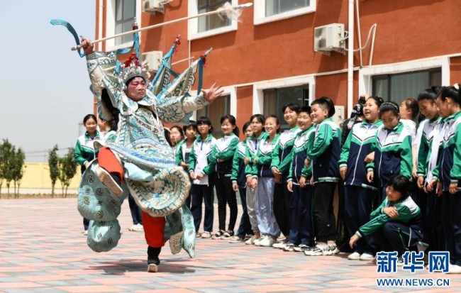 2021年5月26日，在河北省石家庄市高邑县南岩中心小学，演员为学生们展示戏曲动作。新华社发（许建园 摄）