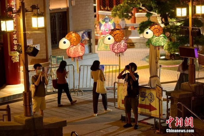 9月6日，为迎接中秋佳节及庆祝黄大仙宝诞，香港啬色园黄大仙祠将于中秋节前后举办花灯庙会等多项活动与民同乐。图为入场人士观赏花灯。 中新社记者 李志华 摄