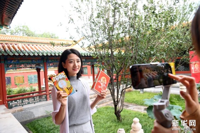9月6日，一名记者在镜头前展示2022年《故宫日历》。新华社记者 金良快 摄