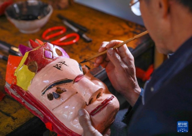 10月17日，肖光华制作思州傩戏傩技表演用的面具。