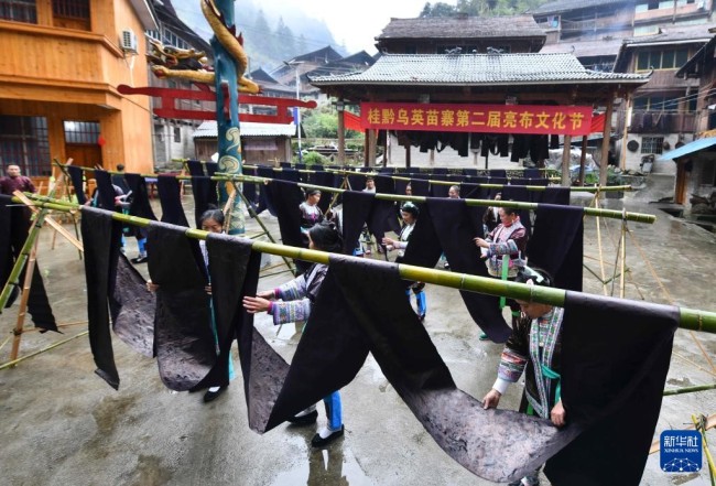 10月19日，在桂黔乌英苗寨亮布文化节上，苗族妇女向游客展示亮布。