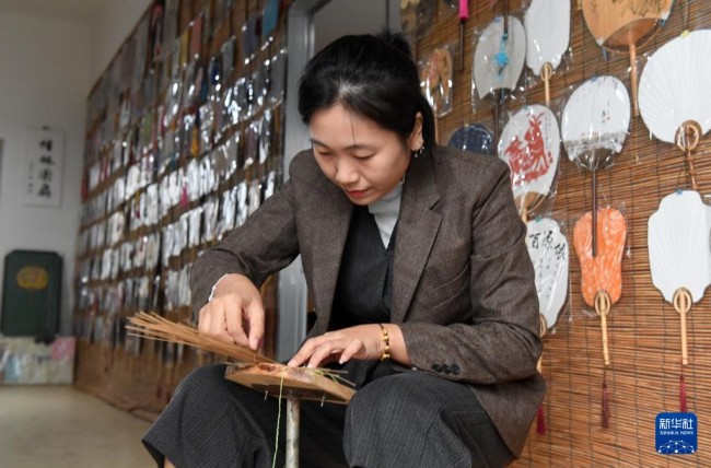 在广西桂林市灵川县定江镇，圆竹剖丝团扇制作技艺传承人黄可人在编扇骨（10月29日摄）。