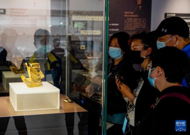 2021年三星堆遗址3号“祭祀坑”出土的金面具，在三星堆博物馆开放式文物修复馆内展出，吸引了众多参观者（10月29日摄）。