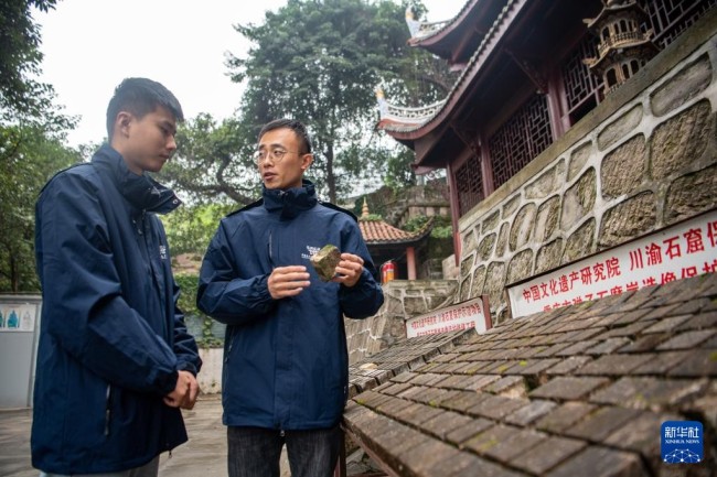 　　11月12日，修缮工程现场技术员王玉超（右）、寻执政在对修复材料进行稳定性评估。新华社记者 唐奕 摄