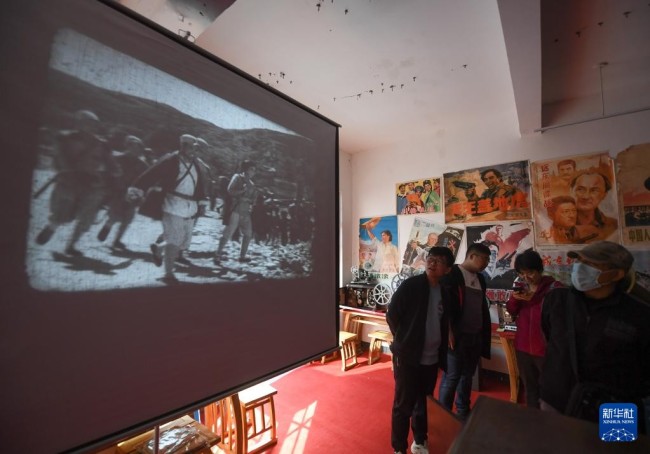 11月20日，在杭州市余杭区瓶窑镇的老街电影博物馆内，游客在观看老式电影放映机放映的老电影。