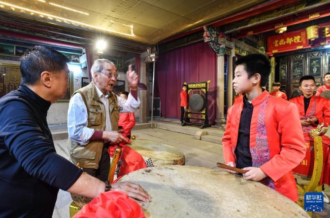12岁的王浩亮（前右）和小伙伴们在汕头市潮南区华瑶村王氏祠堂练习潮州大锣鼓，74岁的潮州音乐艺术家丁增钦（左二）义务指导这支少年潮乐团。