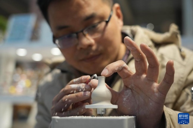 12月14日，王文化在进行微型陶瓷作品“利坯”工序。