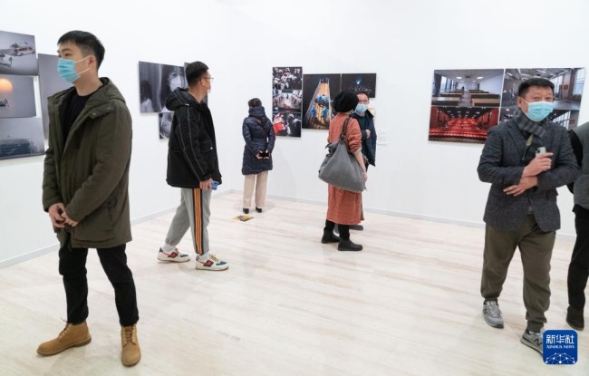 12月28日，在北京首都博物馆举行的第四届全国青年摄影大展上，观众在观看展览。