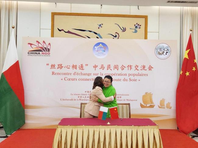 马达加斯加DEFI协会会长安吉莉娜女士（Angeline Volanirina）（左一）与青爱基金会理事长张银俊女士完成协议签署后，以拥抱方式庆祝战略合作达成。