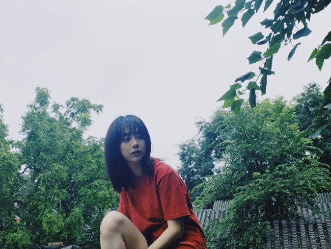 谭松韵胡同随心拍氛围感足 举透明伞超俏皮