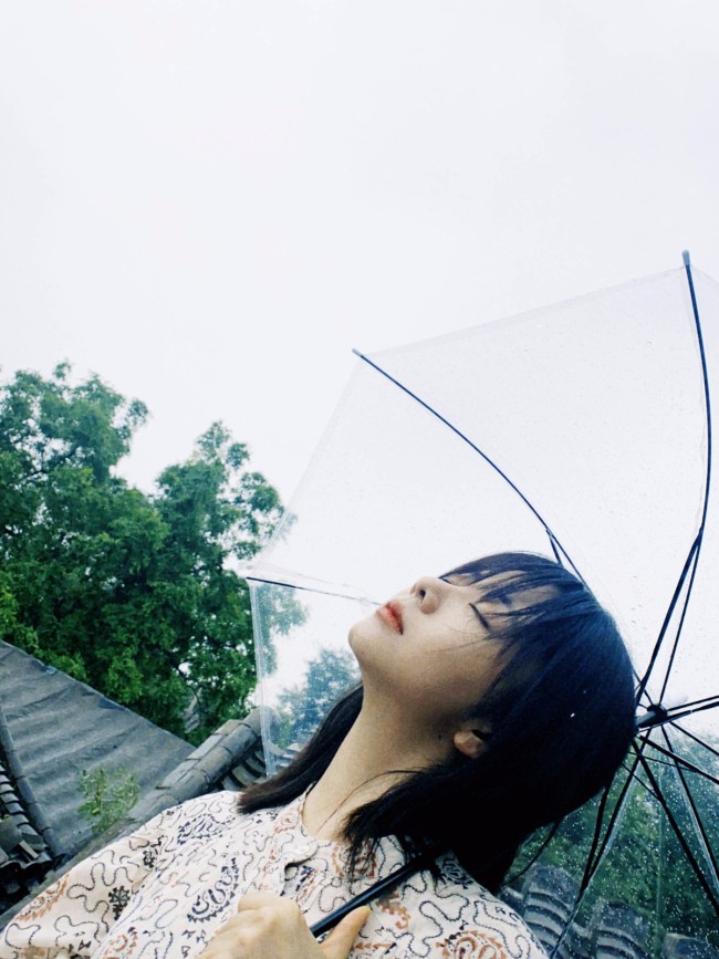 谭松韵胡同随心拍氛围感足 举透明伞超俏皮