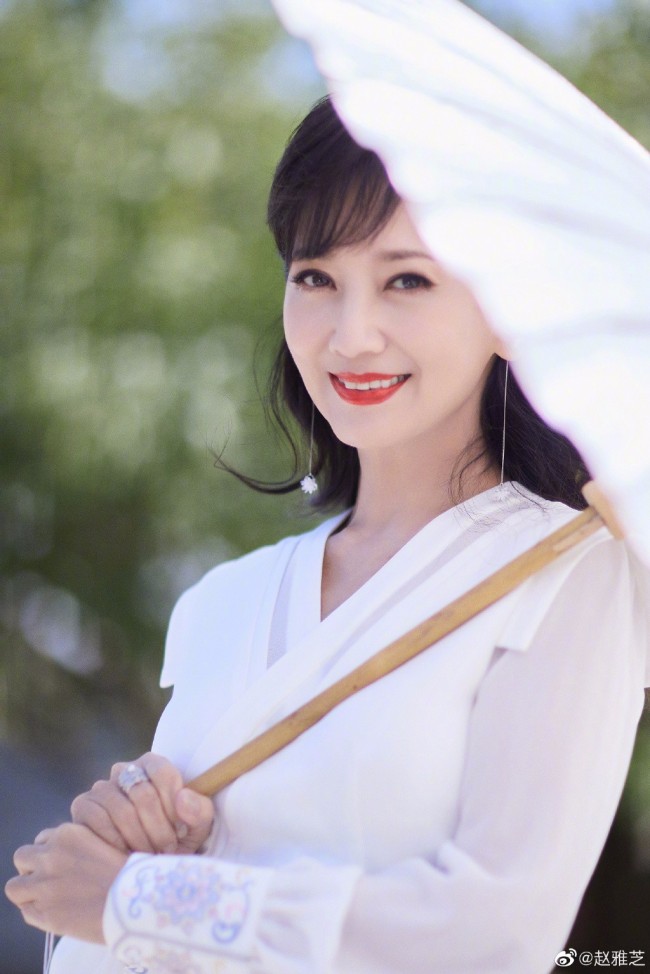 68岁赵雅芝穿白裙优雅迷人 撑油纸伞漫步桥上