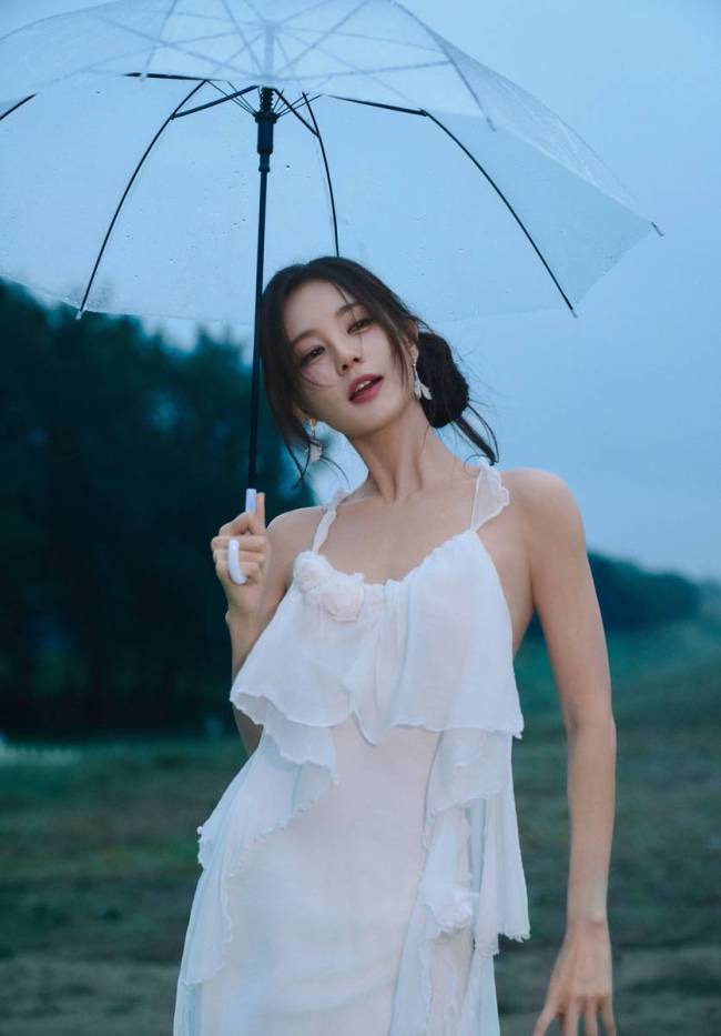 李一桐穿白色吊带裙身材窈窕 雨中撑伞氛围感十足