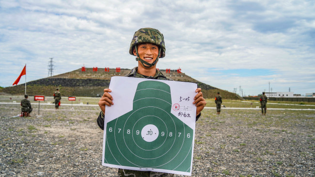 战士邹家宝取得自动步枪精度射击50环，并与之合影留念。