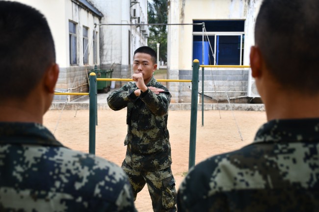 石海军正在为战友讲解动作要领  陈业发摄