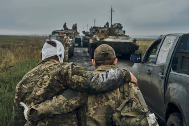 9月12日，在乌克兰哈尔科夫地区，一名乌克兰士兵搀扶另一名受伤的战友。