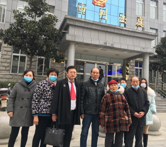 此案被害人家属与代理律师在法院门口。受访者供图 