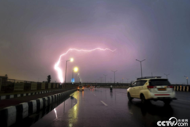 央视网消息：当地时间2021年6月4日，印度诺伊达，市民在雨中出行。当日，印度多个地区遭遇暴雨天气。视觉中国
