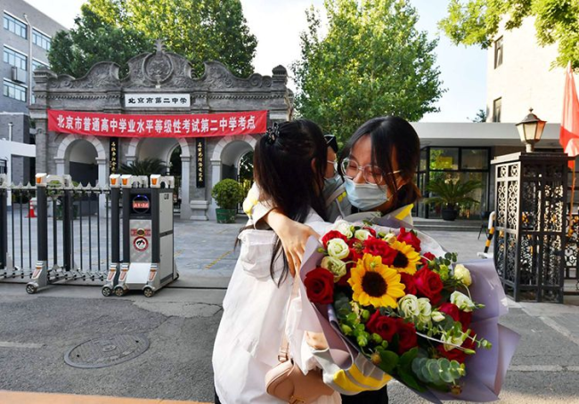 走出考场的考生收到闺蜜送来的鲜花。新京报记者 李木易 摄