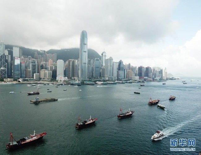 7月1日，插满旗帜的渔船在香港维多利亚港巡游（无人机照片）。新华社记者 李钢 摄