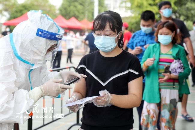 8月9日拍摄于扬州邗江区邗江中学检测点，医护人员正在为居民进行核酸采样。